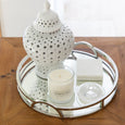 Top view of mirrored tray with chrome handles styled on wooden table
