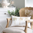 Royal Mirage Palms Lumbar Cushion styled on a rattan armchair in a Hamptons-inspired living space with coastal décor and soft neutral furnishings.