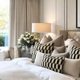 Royale Belmont Lattice cushion layered on a luxury bed with neutral cushions and soft furnishings in a contemporary Hamptons-inspired bedroom.