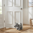 Grey fabric dog door stop holding open a white interior door in a Hamptons-style hallway