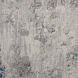 Detailed view of the Seacliff Mist Rug showcasing layered floral textures in ivory, grey, mist blue and warm stone.