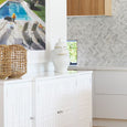 Natural seagrass lantern styled on a white console with coastal decor and textured neutral interiors.