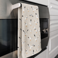 Coastal seagull tea towel draped over oven handle in modern white kitchen