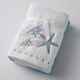 Seaside Hand Towel Set of 2, featuring one embroidered white towel with seashell and starfish design and one plain white towel, tied with a white ribbon.