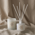 White Shoreline diffuser and candle styled on soft linen fabric creating a calm coastal atmosphere