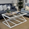 Southampton white coffee table styled in a coastal living room with blue armchair and glass top detail