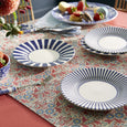 Spode Steccato bold stripe side plates styled on a colourful table setting with coordinating blue and white tableware.
