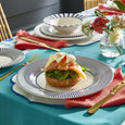 Spode Steccato dinner plate styled in an elegant tablescape with coordinating blue and white dinnerware, gold cutlery and fresh flowers.