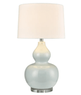 Light blue ceramic table lamp with classic white shade on a bedside table
