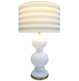 Tall Hamptons style table lamp with neutral striped shade on bedside table
