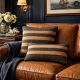Matching Tobacco Weave lumbar and square cushions styled on a caramel leather sofa with navy wall panelling, creating a warm contemporary living room.
