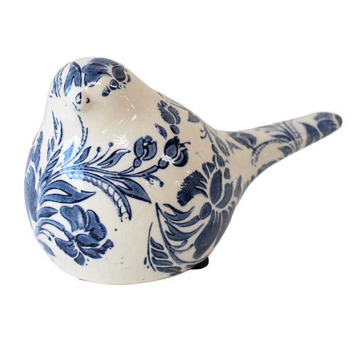 Ceramic bird figurine with blue floral patterns on a white background