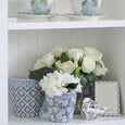 Blue and white ceramic bird styled on shelf with flowers and decorative pieces
