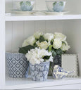 Blue and white ceramic bird styled on shelf with flowers and decorative pieces