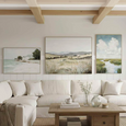 Whispers of the Coast Wall Art styled with coastal landscape artworks above a neutral living room sofa