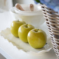 Macy Porcelain Oval Platter styled with decorative green apples in a relaxed Hamptons-inspired interior.