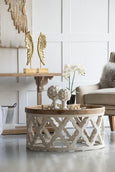 Round coffee table with weathered white lattice detailing and whitewashed wood top viewed from an angle