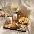 Wildflower & Hive breakfast kitchen collection styled with butter bell, egg cups, salt and pepper shakers, toast, and ceramic napkin holder on timber serving board