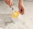 Soft spreadable butter inside Wildflower & Hive white butter bell on marble benchtop