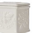 Close-up detail of embossed bee and botanical pattern on white ceramic salt cellar
