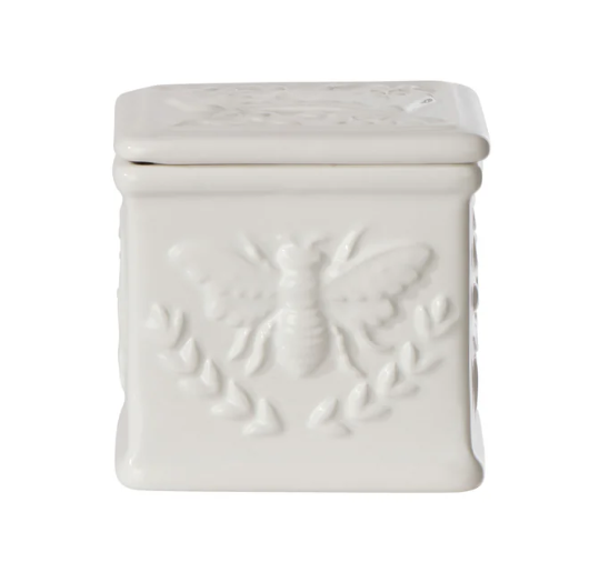 White ceramic salt cellar with embossed bee detail and lid