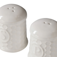 Close-up detail of Wildflower & Hive white dolomite salt and pepper shakers with honeycomb pattern