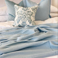 Baby blue cotton waffle weave blanket styled on a bed with matching blue pillows in a Hamptons-style bedroom