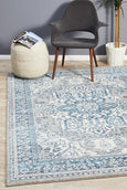 Bridgeport Blue rug styled under a light-coloured sofa, showing textured blue and ivory pattern in a coastal living space