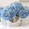 Blue hydrangea bundle styled in a silver bowl on a white kitchen island in a Hamptons style home