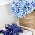 Blue hydrangea bundle styled in a rattan pot with other decor items in a Hamptons style home