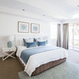 Rodeo Ocean Rectangle Cushion in dusky vintage blue velvet with white piping, styled on coastal Hamptons bed setting"