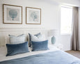 Rodeo Ocean Rectangle Cushion in dusky vintage blue velvet with white piping, styled on coastal Hamptons bed setting"