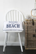 Rectangular cushion with “Welcome to the Beach” text in navy on a neutral background.