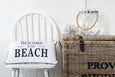 Rectangular cushion with “Welcome to the Beach” text in navy on a neutral background.