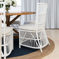 White rattan dining chairs with timber table in Hamptons style dining room